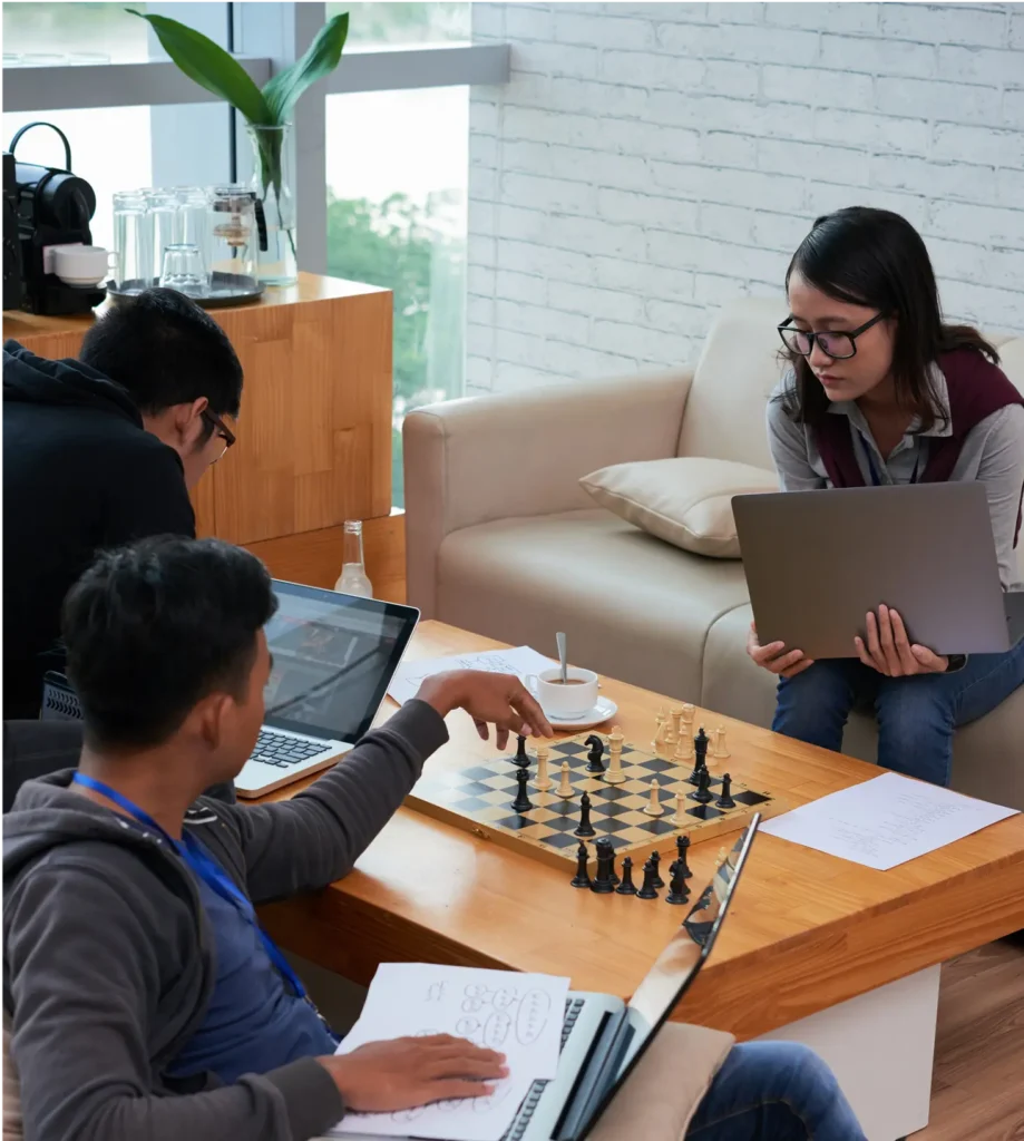 people playing chess and working on laptops